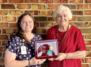 WPHD staff show an award plaque for model practice.