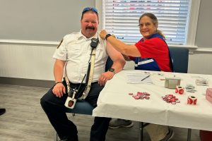 A medical reserve corps volunteer prepares to vaccinate a community member for flu season.