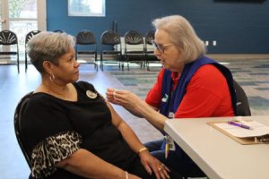 A person puts a bandage on another person's arm.